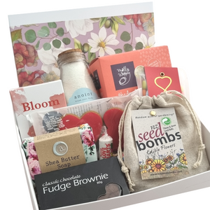 White floral gift box with body care, candles, chocolate and seed bombs to grow