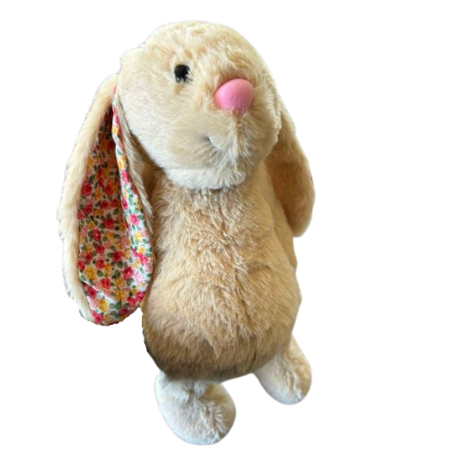 Fluffy brown rabbit toy with floral ears on white background